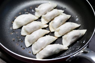 El yapımı hamur köftelerini kızartma tavasında pişir..