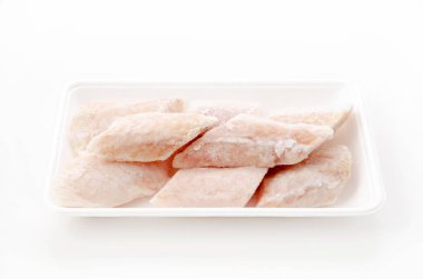 Donmuş çiğ fileto Kamçatka pisi balığı. Beyaz arka planda köpük tepside.