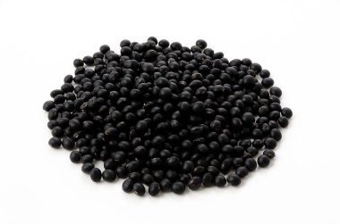 Pişmemiş siyah fasulyeler beyaz arkaplanda izole edilmiş.