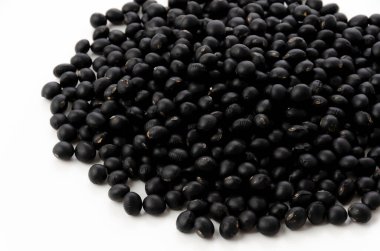 Pişmemiş siyah fasulyeler beyaz arkaplanda izole edilmiş.