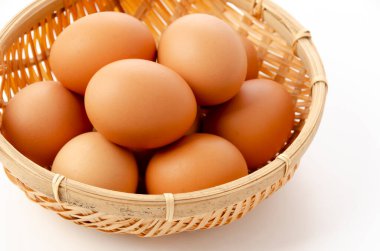 Kahverengi tavuk yumurtaları beyaz arka planda bambu eldiveni.