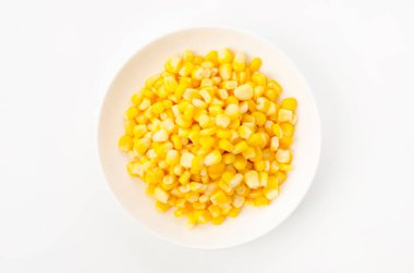 Canned sweet corn on a white plate on white background