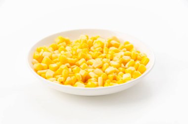 Canned sweet corn on a white plate on white background