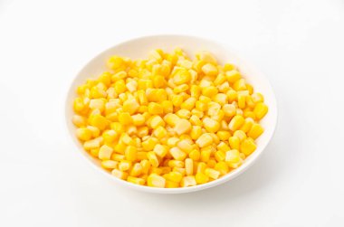 Canned sweet corn on a white plate on white background