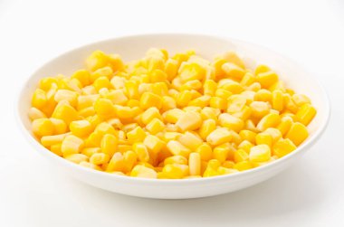 Canned sweet corn on a white plate on white background