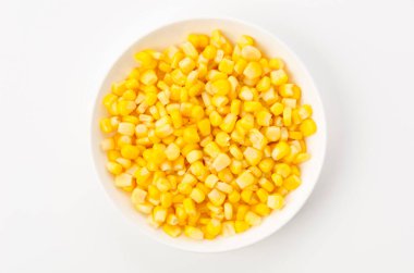 Canned sweet corn on a white plate on white background