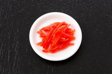 Benishoga, siyah taş arka planda kızıl turşu.