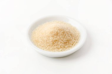 San-ontou, beyaz arka planda beyaz tabakta açık kahverengi şeker.