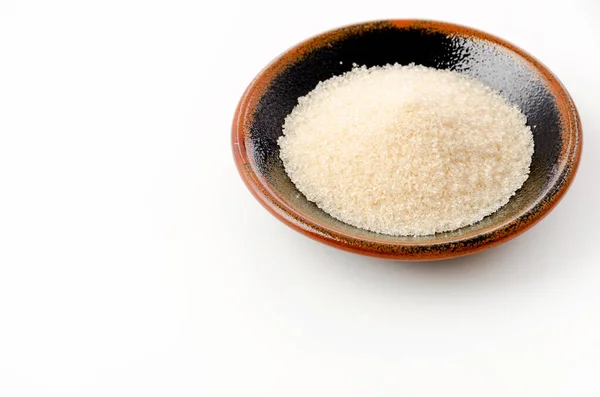 stock image San-ontou, Light brown sugar in a black plate on white background