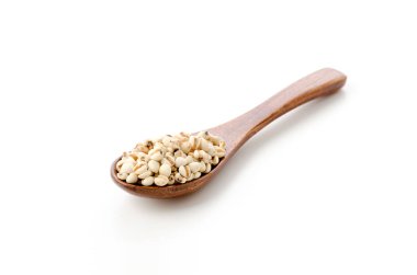 Eyüp 'ün gözyaşları (Adlay darı) beyaz arkaplanda tahta kaşıkla