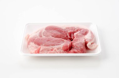 Beyaz arka planda köpük tepside çiğ domuz eti