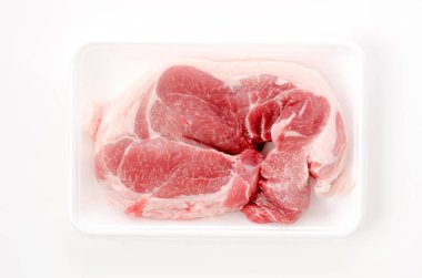 Beyaz arka planda köpük tepside çiğ domuz eti