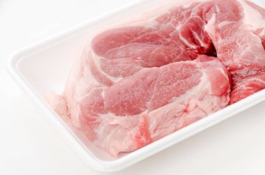 Beyaz arka planda köpük tepside çiğ domuz eti