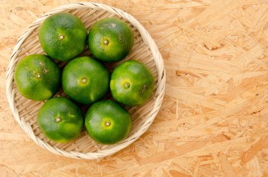 Citrus unshiu, Mandarin satsuma orange bambu elek üzerinde kontrplak arka planda