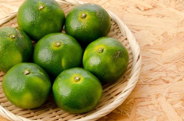 Citrus unshiu, Mandarin satsuma orange bambu elek üzerinde kontrplak arka planda