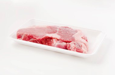 Beyaz arka planda köpük tepside çiğ domuz eti