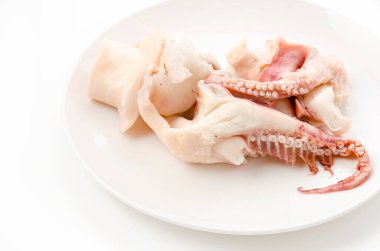 Beyaz arka planda kaynamış mürekkep balığı bacakları.