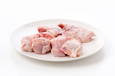 Beyaz arka planda beyaz tabakta çiğ tavuk eti.