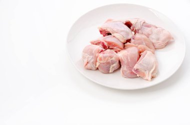 Beyaz arka planda beyaz tabakta çiğ tavuk eti.