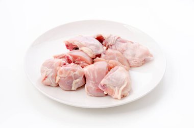 Beyaz arka planda beyaz tabakta çiğ tavuk eti.
