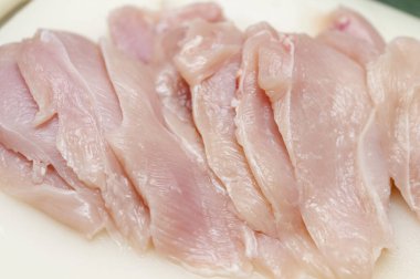 Kesme tahtasında çiğ tavuk göğsü. Derisi yüzülmemiş taze tavuk pişirme hazırlığı.