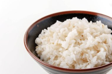 Beyaz arka planda bir kase arpa karışık pirinç..