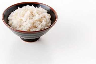 Beyaz arka planda bir kase arpa karışık pirinç..