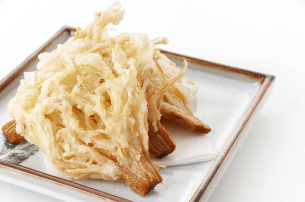 Enoki Mushroom Tempura,Crispy enoki mushroom tempura served on a plate against a white background.