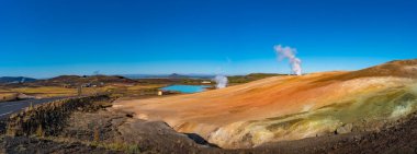 Myvatn Gölü ve İzlanda 'nın Reykjahlid kasabası yakınlarındaki jeotermal aktif bölgeler üzerine panoramik manzara, yaz ve mavi gökyüzü Mars kızıl gezegenine benzer..
