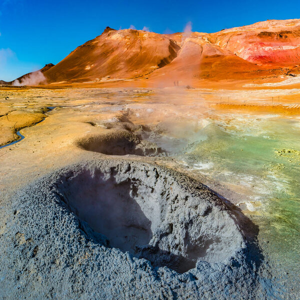 Colorful geothermal active zone Hverir near Myvatn lake in Iceland, resembling Martian red planet landscape, at summer and blue sky