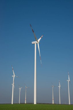 Elektrik enerjisi üretmek için büyük rüzgar türbinleri grubu, Avrupa 'nın mavi gökyüzünde yeşil eko-dostluk enerjisi. Yeşil sürdürülebilir enerji üretimi ve akıllı sanayi kavramı.