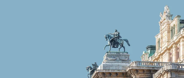 Banner with top roof sculpture of Greek goddess Muse riding Pegasus, a winged horse, at Vienna State Opera House, Vienna, Austria, with copy space. Concept of Cultural Heritage and Travel