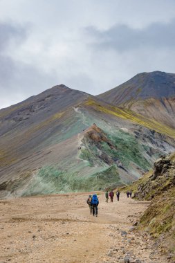 İkonik renkli gökkuşağı volkanik dağlarına Landmannalaugar 'a Laugahraun lav tarlasına ve İzlanda' daki yürüyüş ekibine bakın. Yaz, dramatik bir manzara.