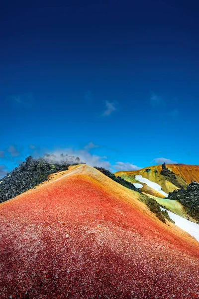 アイスランドのLandmannalauar山の象徴的なカラフルな虹火山のマウントBrennisteinsalda 青空とスモーキー溶岩フィールドと劇的な風景 — ストック写真