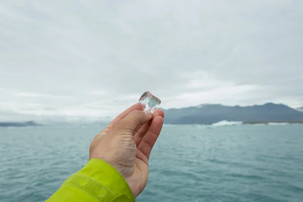 Peice di ghiaccio fondente ghiacciaio in mano all'uomo in Islanda, estate ti — Foto Stock