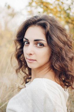 Güzel bir esmerin portresi. Gün batımında açık alanda..