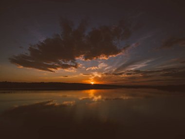 Nehrin üzerinde turuncu-altın rengi muhteşem bir gün batımı. Hava kararmak üzere..