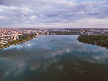 Şehir seti ve şehir manzaralı bir nehrin üzerinde gün batımı. Yılın en sıcak zamanı. Altın saat.