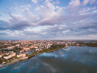 Şehir seti ve şehir manzaralı bir nehrin üzerinde gün batımı. Yılın en sıcak zamanı. Altın saat.