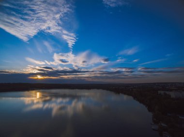 Ufukta orman olan bir nehrin üzerinde gün batımı. Hava kararmak üzere..
