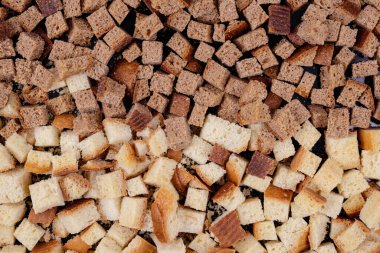 Koyu arkaplanda kavrulmuş beyaz ve kahverengi ekmek parçaları. Lezzetli kızarmış ekmeklerin yakın çekimi..