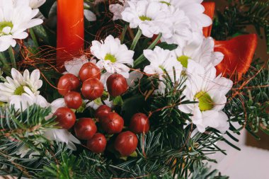 Noel buketi dallardan, ladin dallarından, beyaz papatyalardan yapılmış baharatlar ve kırmızı yayla süslenmiş..