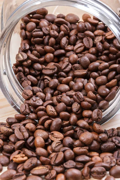 Verstreute Kaffeebohnen Aus Glasflasche Auf Holztisch — Stockfoto