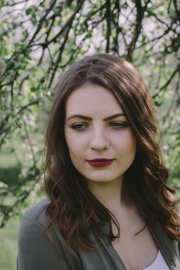 Bahçedeki ağaçların altında güzel bir esmerin portresi. Bahar geldi..