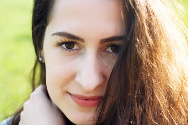 Güzel esmer bir kızın açık hava portresi. Gülümseyen mutlu bir kadının yakın plan portresi.. 