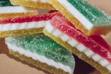 Çok renkli marmelatlı reçelli şekerler. Bej arka planda üçgen marmelat şekeri yığını. Macro, seçici odaklanma.