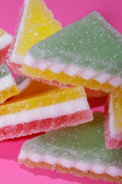 Pembe arka planda üçgen şeker yığını. Macro, seçici odaklanma.