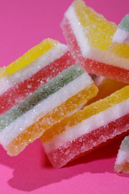 Pembe arka planda üçgen şeker yığını. Macro, seçici odaklanma.