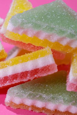 Pembe arka planda üçgen şeker yığını. Macro, seçici odaklanma.