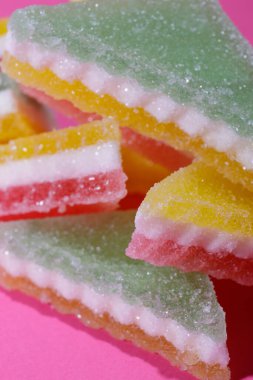 Pembe arka planda üçgen şeker yığını. Macro, seçici odaklanma.